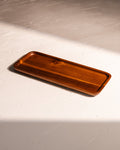 Acacia wood tray with warm lacquered finish and visible natural grain