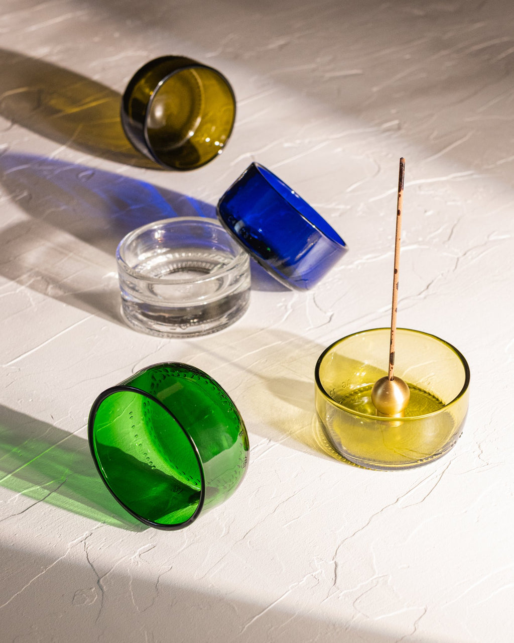 Reclaimed bottle glass dishes in amber, olive, blue, green, and clear with incense holder