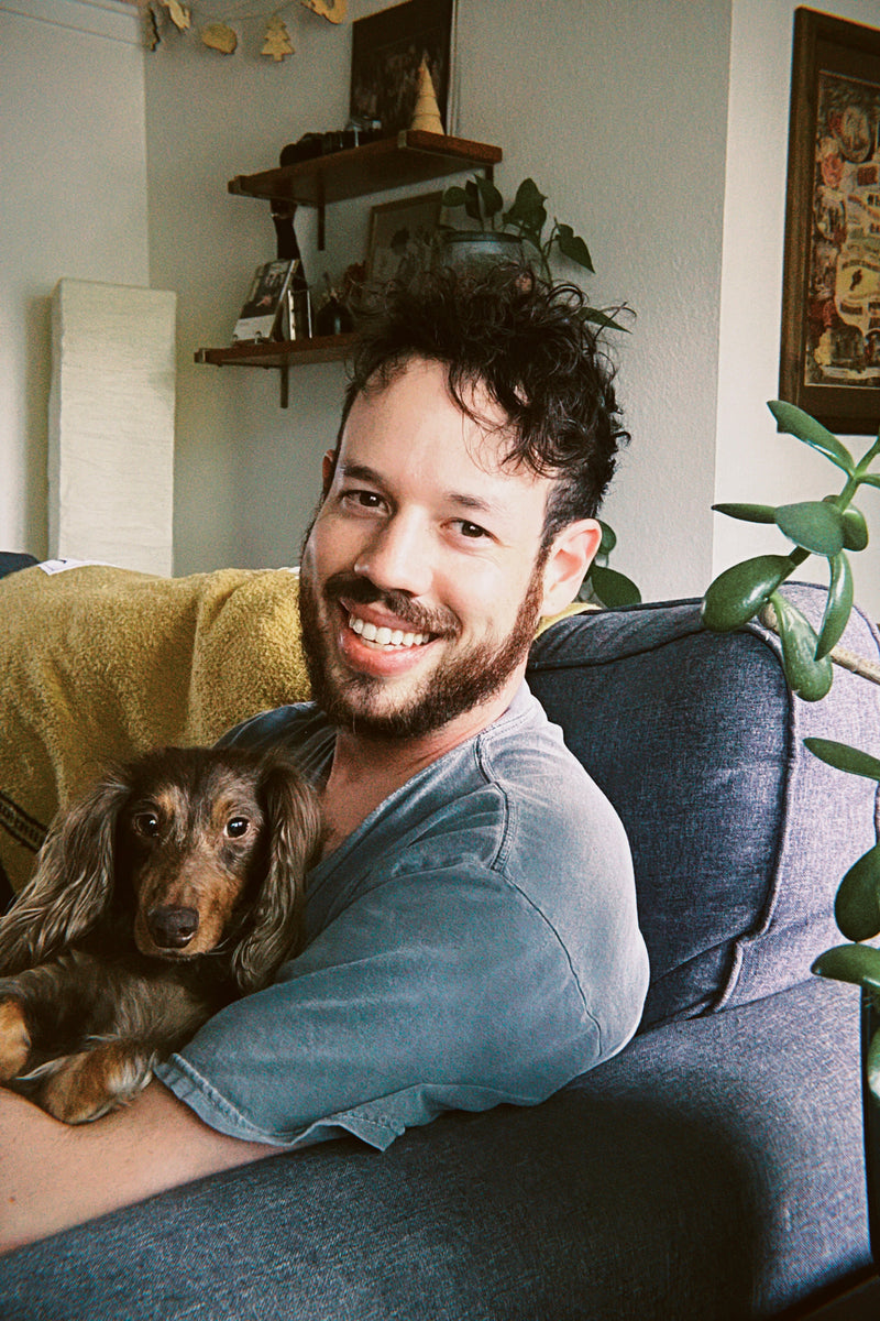 portrait of Brett Owens at home with mini dachshund, Crosby