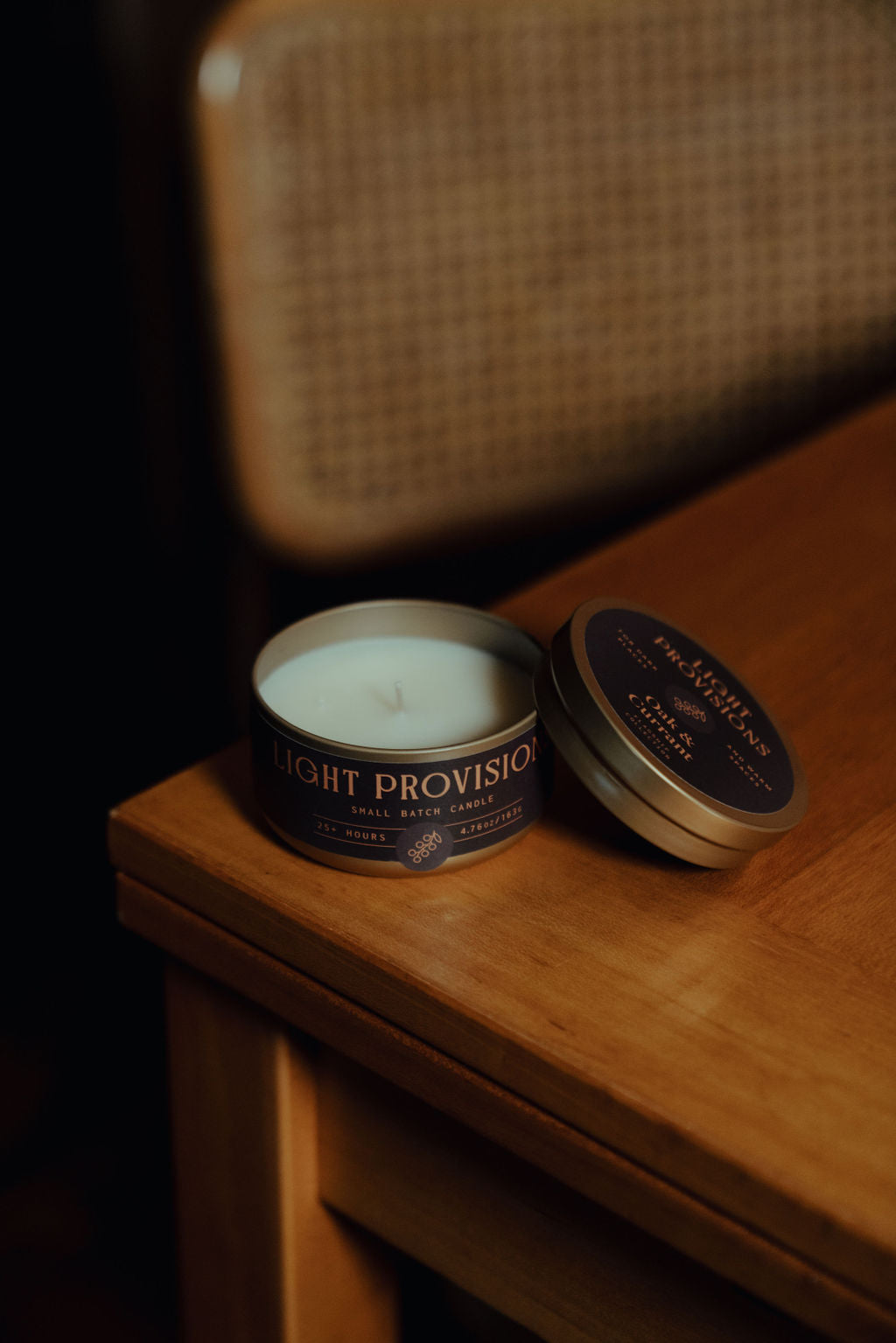 Oak and Currant travel tin candle open showing white wax with lid nearby on wooden table