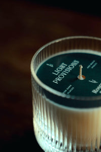 Close-up macro of the tumbler’s ribbed rim and green top label; shallow depth of field on the exposed wick.