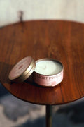 Rose & Fir candle tin with lid open showing white wax on wooden table