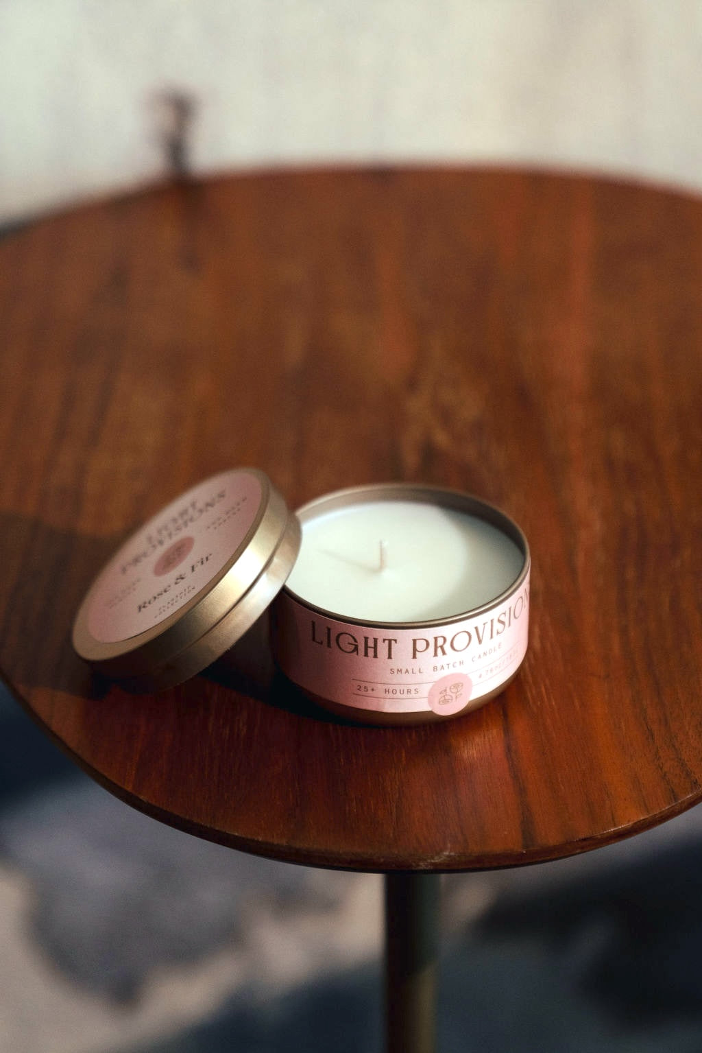 Rose & Fir candle tin with lid open showing white wax on wooden table