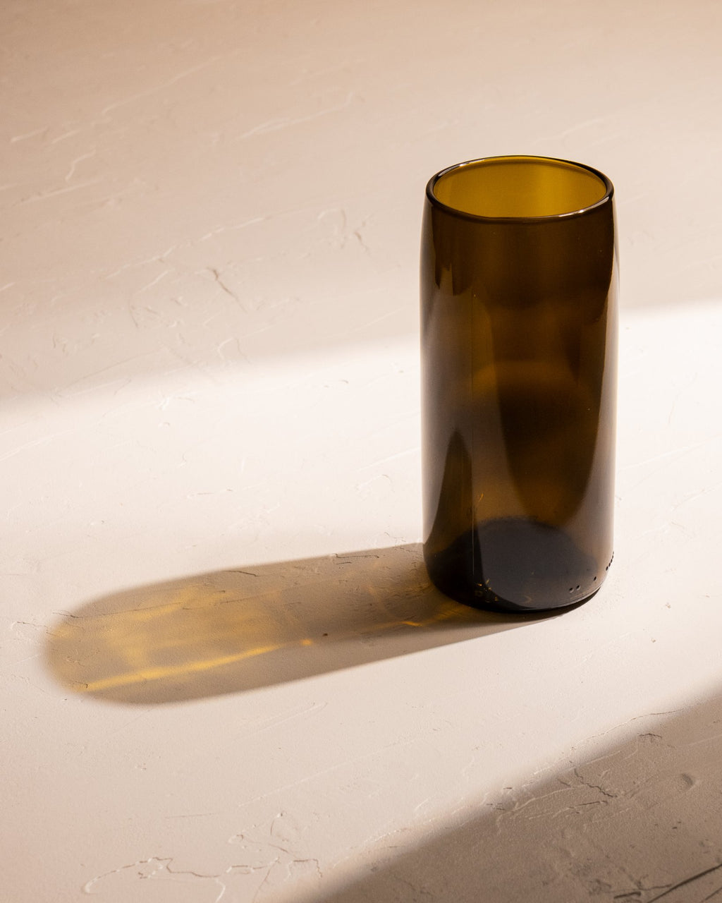 Antique Green recycled wine bottle incense vase with warm brown glass and soft shadow.