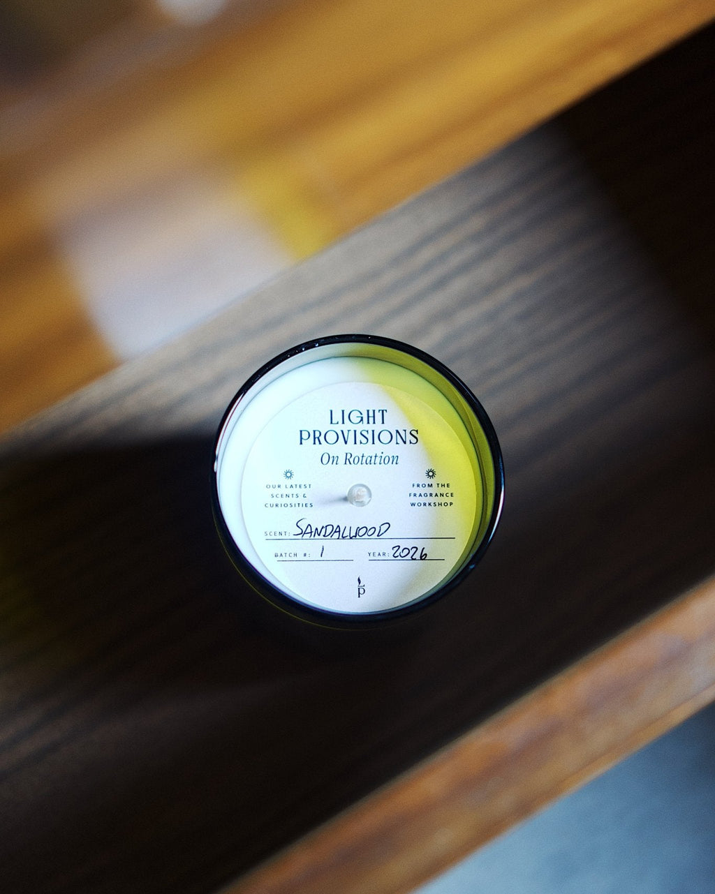 On Rotation Sandalwood candle in an antique green recycled wine bottle vessel.