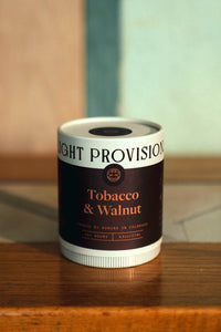 Light Provisions Tobacco & Walnut 9.5 oz glass tumbler candle packaging with black label and copper lettering.