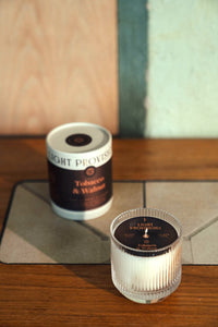 Tobacco & Walnut candle set with ribbed glass tumbler in foreground and tumbler packaging in background.