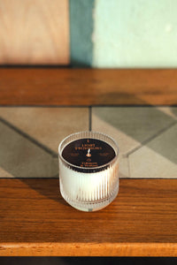Close-up of Tobacco & Walnut ribbed glass tumbler candle with black label lid, unlit wick.