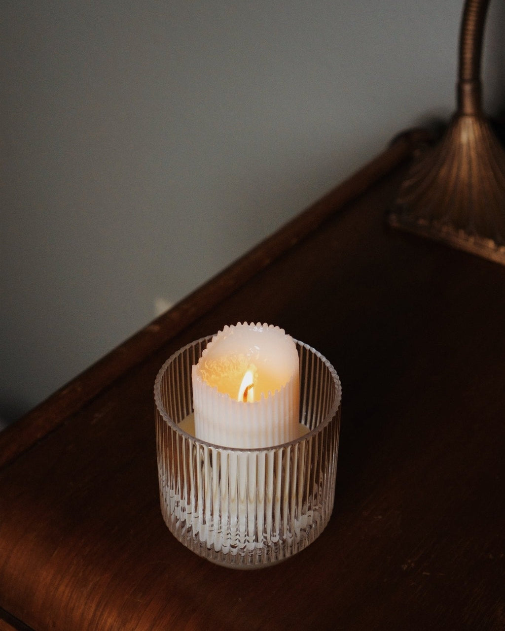 Refill Candle in a decorative holder on a wooden surface with a soft focus background