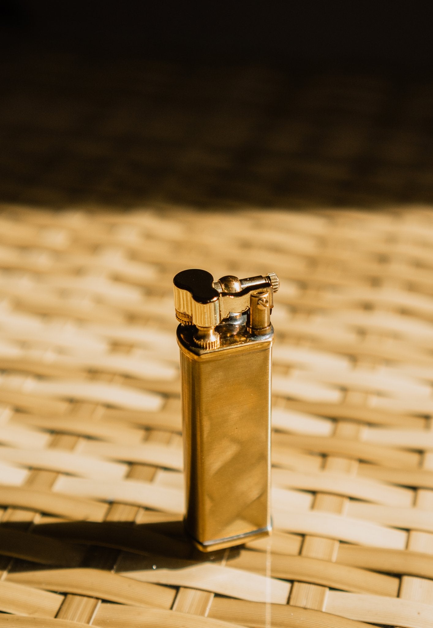 Brass Bolbo Petrol Lighter by Tsubota Pearl on bamboo surface, refillable petrol lighter from Japan.