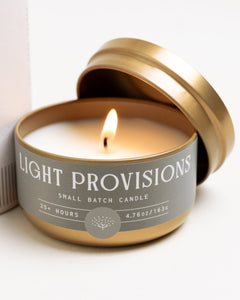 Palo Santo + Ginger travel candle in gold tin with citrus, coconut husk, and warm resin notes.
