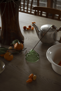Verde green Meso Glass Incense Holder holding incense stick styled with ceramic teapot and fruit by Yield Design Co
