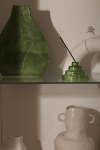 Verde green Meso Glass Incense Holder holding incense stick styled on shelf with vases in warm golden light by Yield Design Co
