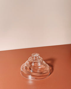 clear glass meso incense holder by yield design on neutral orange background
