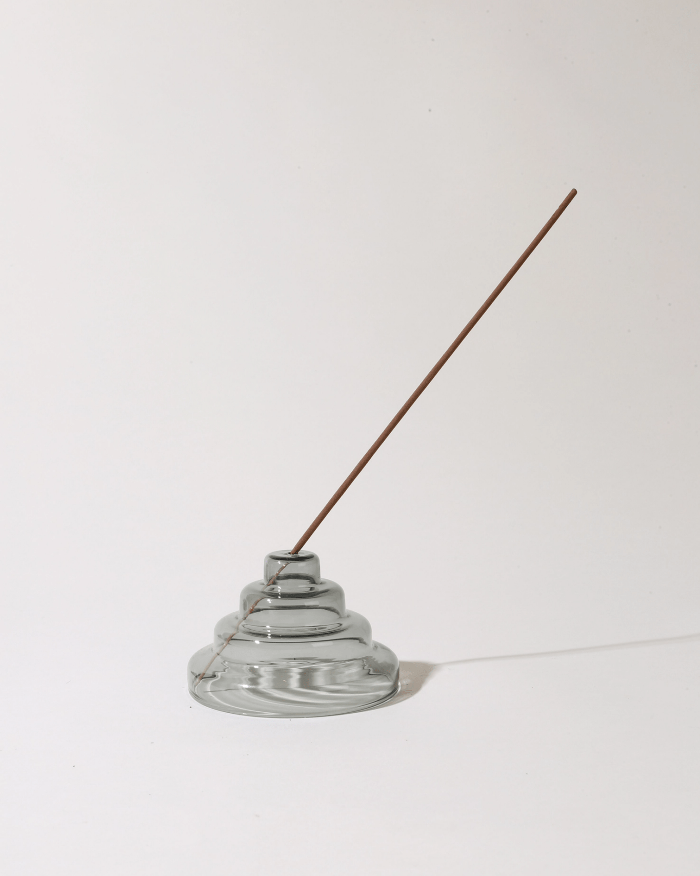 Incense holder with a single incense stick on a white background