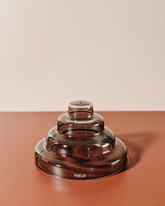 gray glass meso incense holder by yield design on neutral orange background