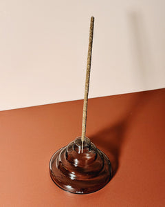 gray glass meso incense holder by yield design on neutral orange background