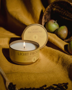 Light Provisions Harvest candle travel tin with branded lid and wicker basket background