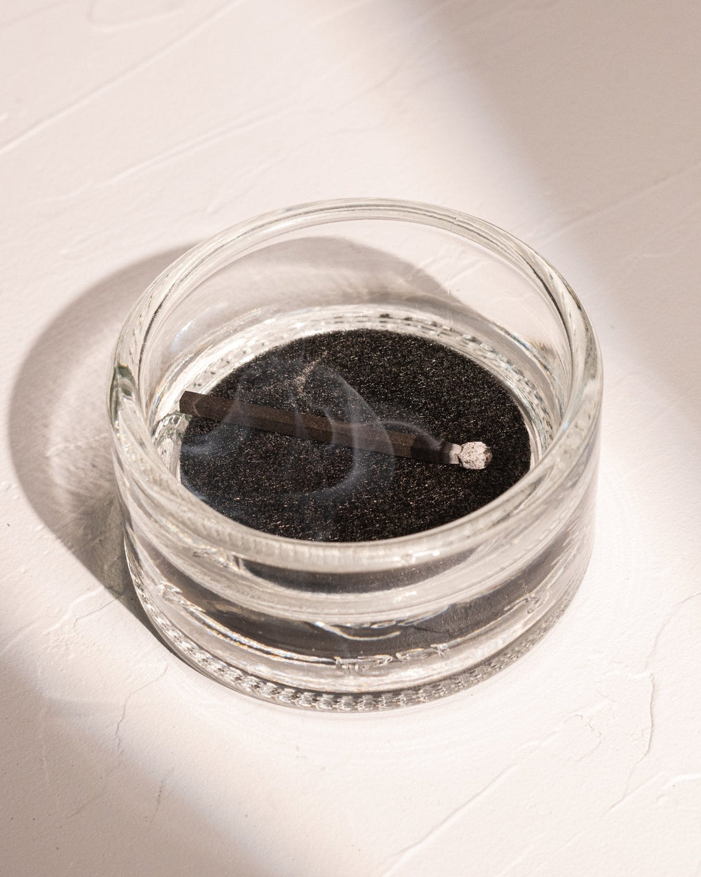HIBI incense match resting in recycled liquor bottle glass incense holder