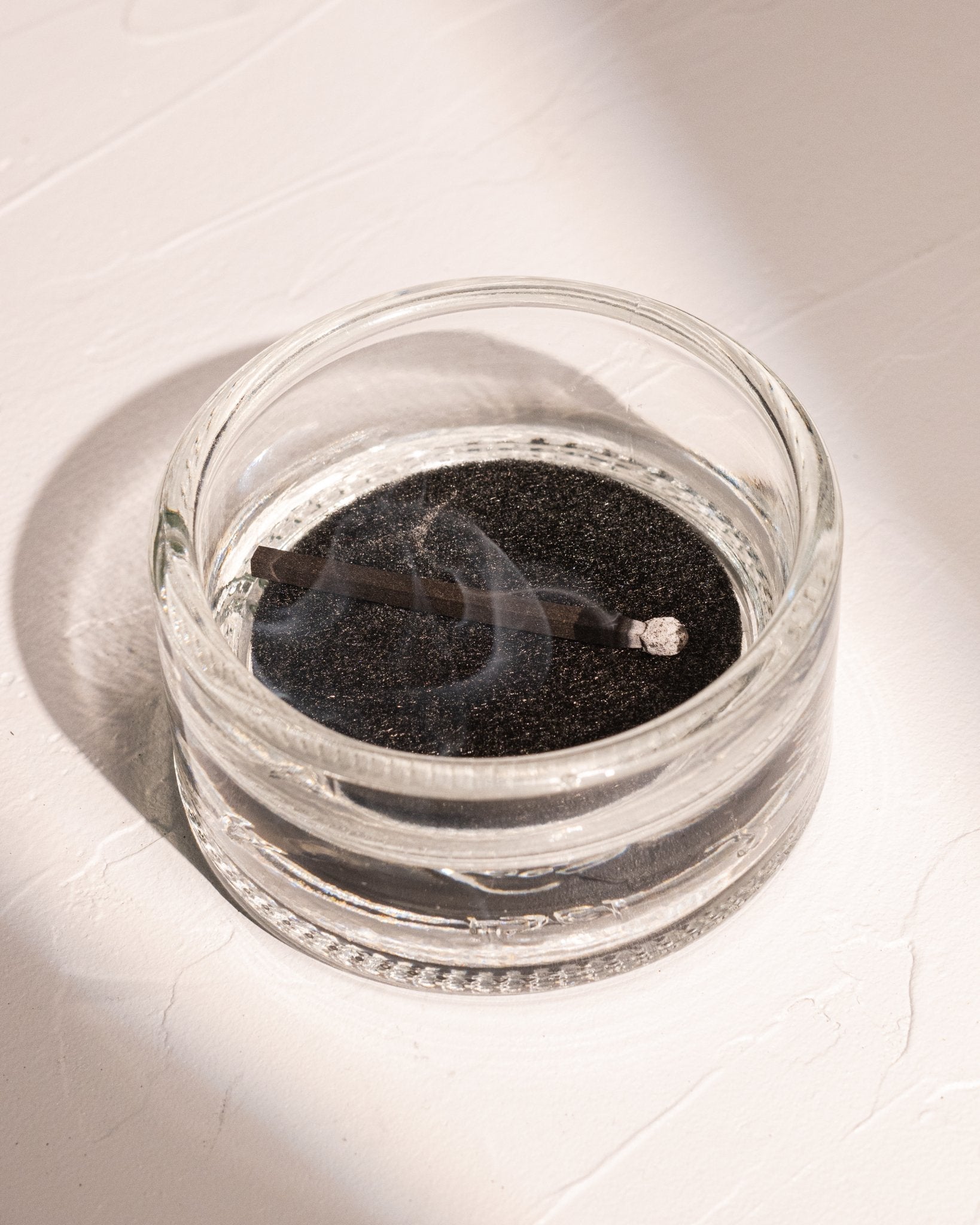 HIBI incense match resting in recycled liquor bottle glass incense holder