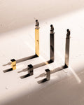 Tsubota Pearl Queue stick lighters in gold, silver, and black with caps removed