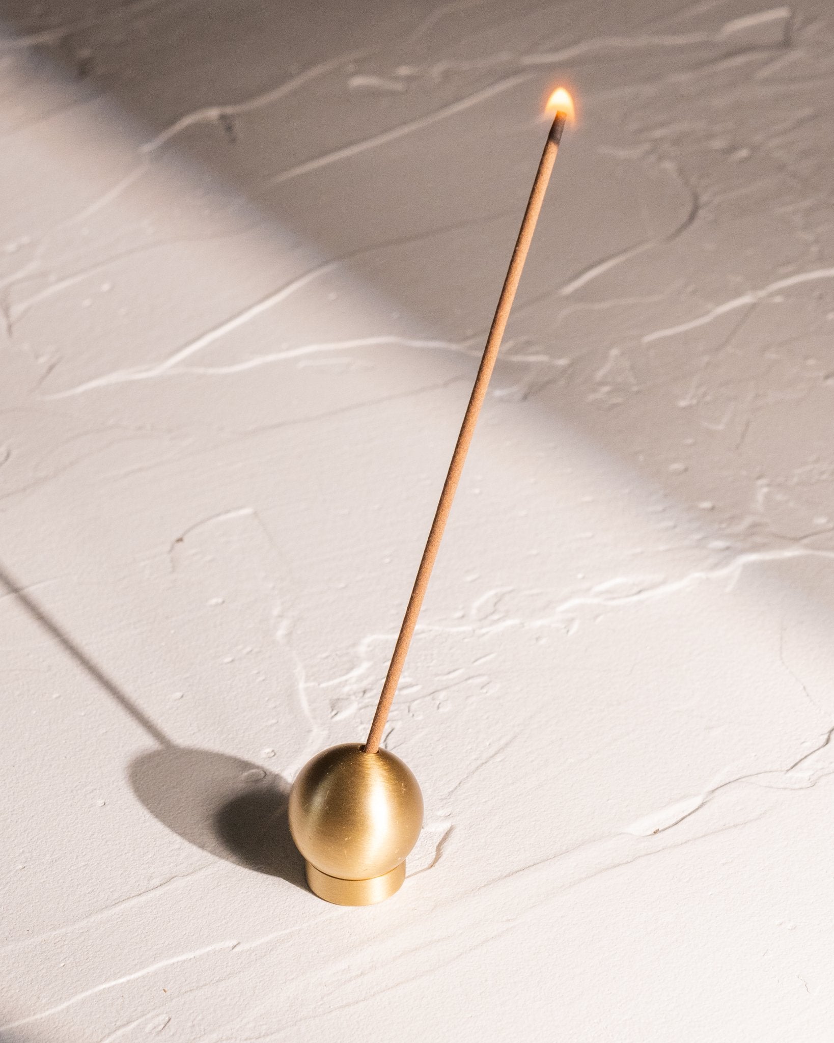 Adjustable brass incense holder with lit incense stick