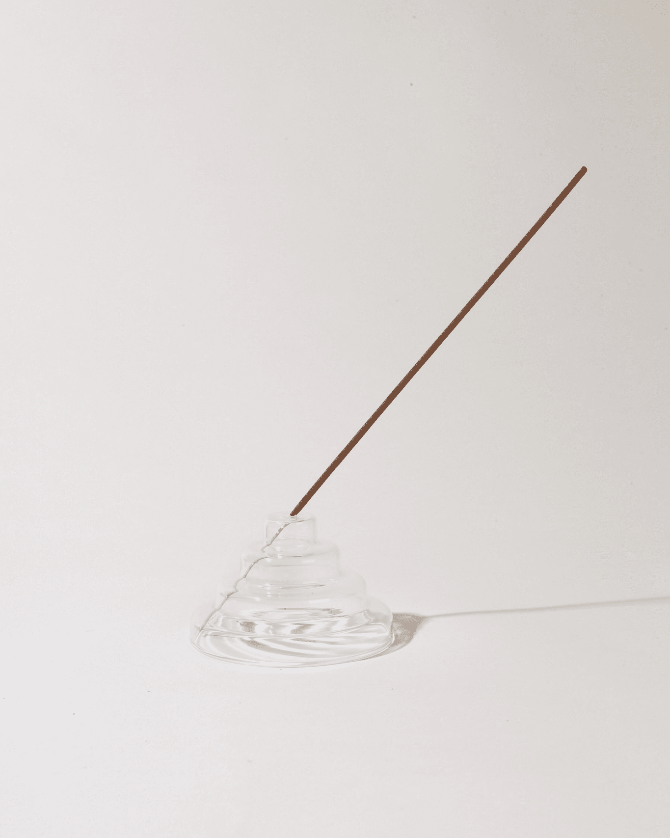 Incense holder with a single incense stick on a white background