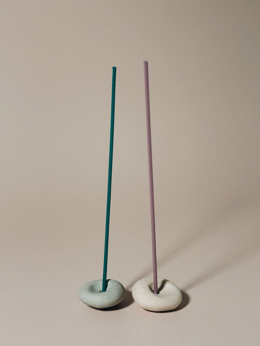 Two Pebble incense holders sit side by side with coreless incense