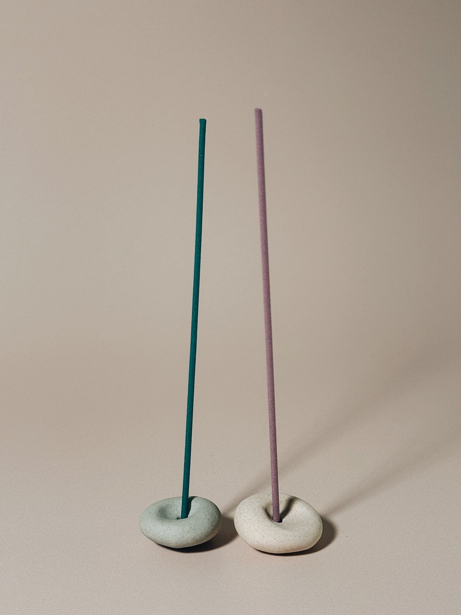 Two Pebble incense holders sit side by side with coreless incense
