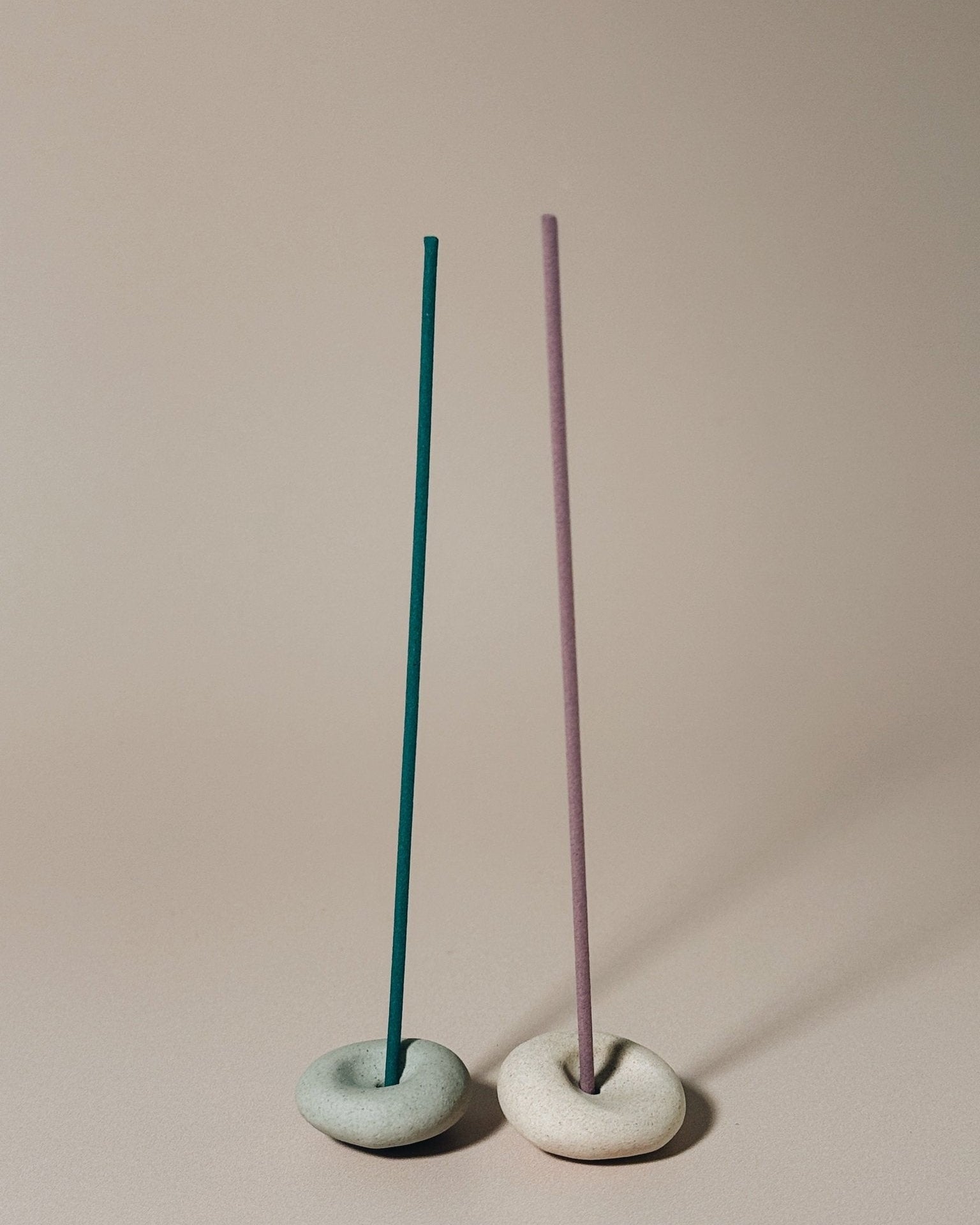 Two Pebble incense holders sit side by side with coreless incense