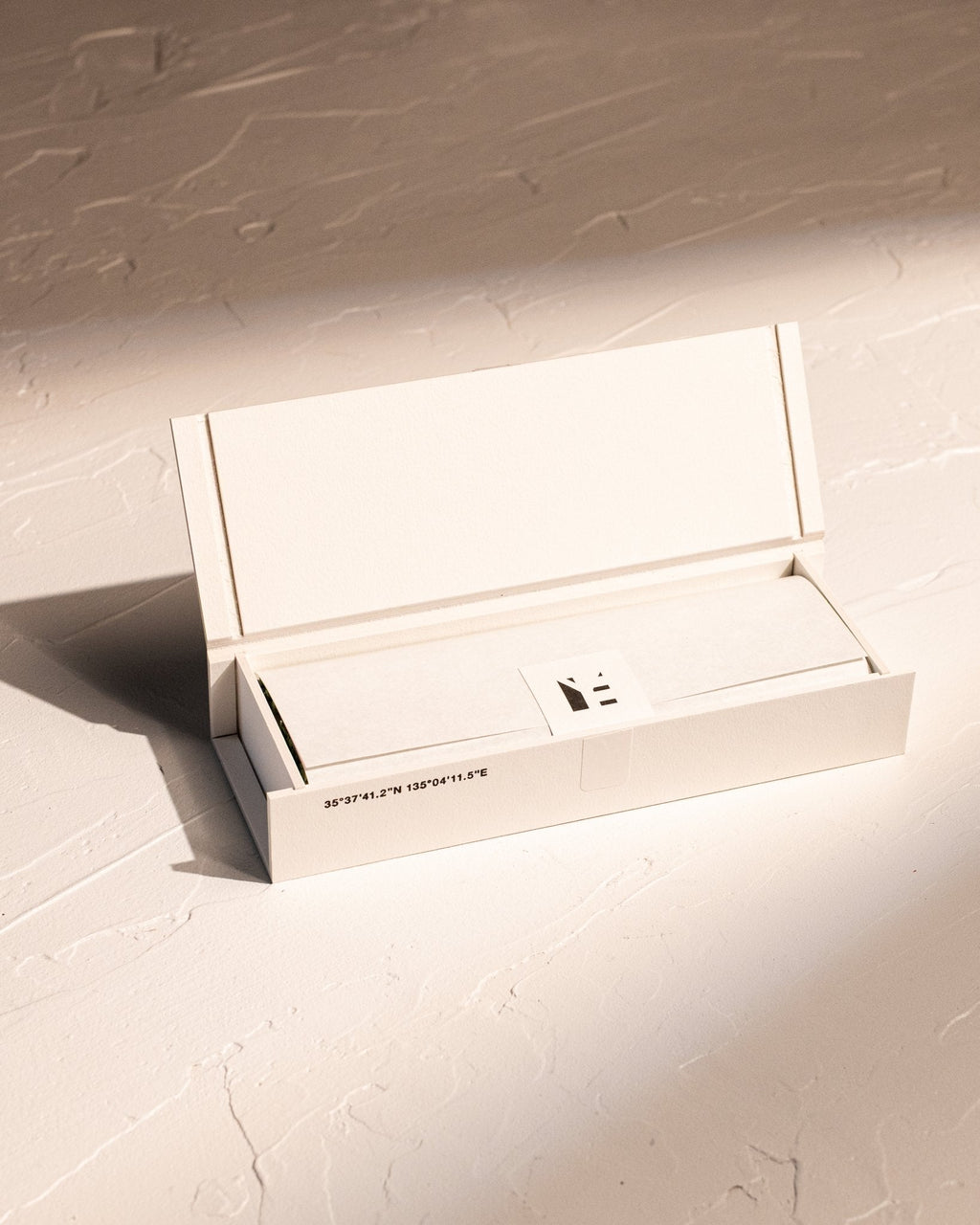 Open box of IYÉ No. 009 Cedarwood, displaying inner paper packaging with minimalistic aesthetic
