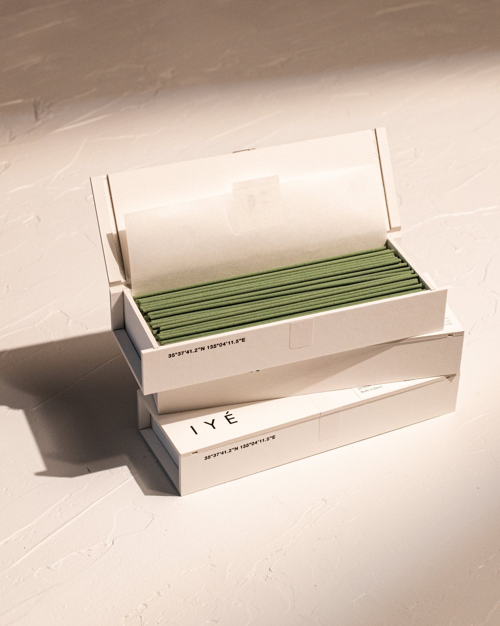 Open box of IYÉ No. 007 Sandalwood incense stacked on other IYE incense boxes