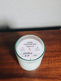 Hand-poured Gypsophila candle in aqua recycled glass with labeled dust cover from Light Provisions On Rotation collection.