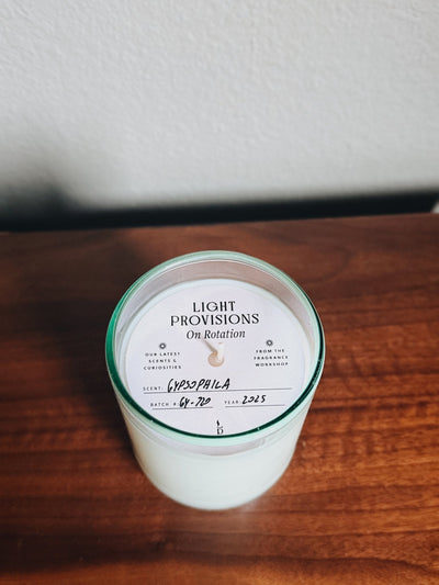 Hand-poured Gypsophila candle in aqua recycled glass with labeled dust cover from Light Provisions On Rotation collection.