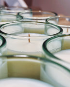 Batch of Gypsophila candles in bright aqua recycled glass, showcasing hand-poured wax and circular glass rims