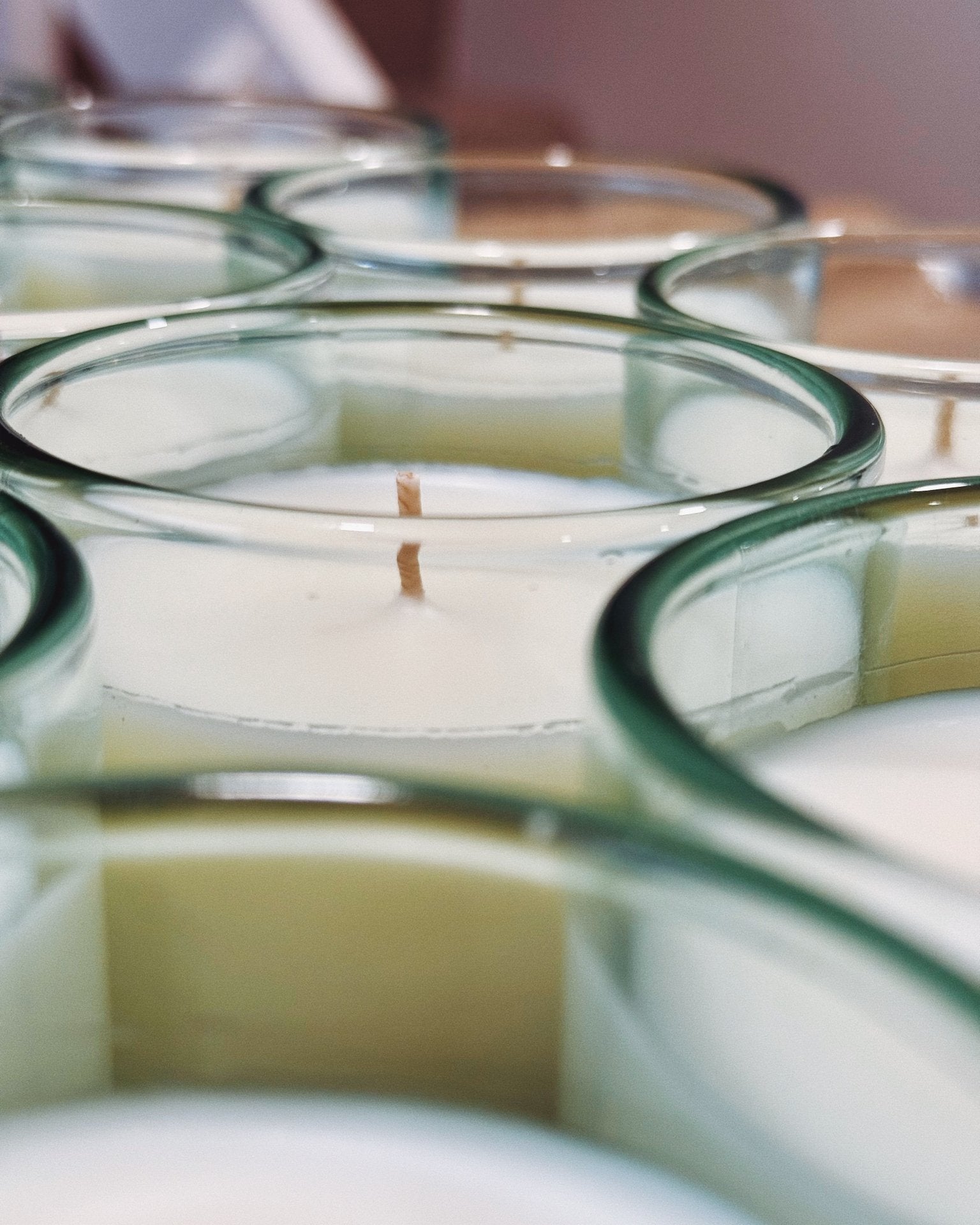 Batch of Gypsophila candles in bright aqua recycled glass, showcasing hand-poured wax and circular glass rims