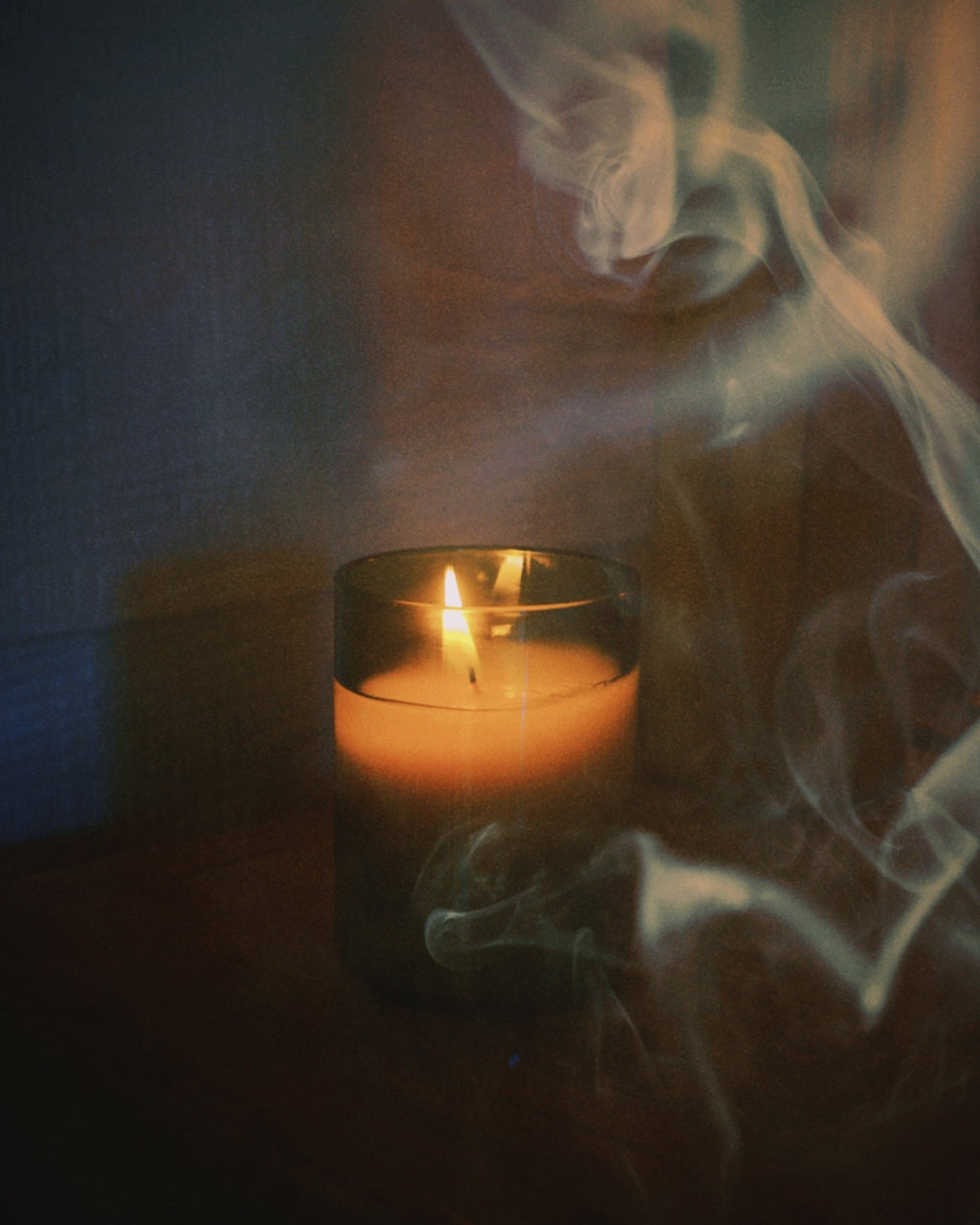 close up of burning light provisions woodsmoke candle with smoke in foreground and background