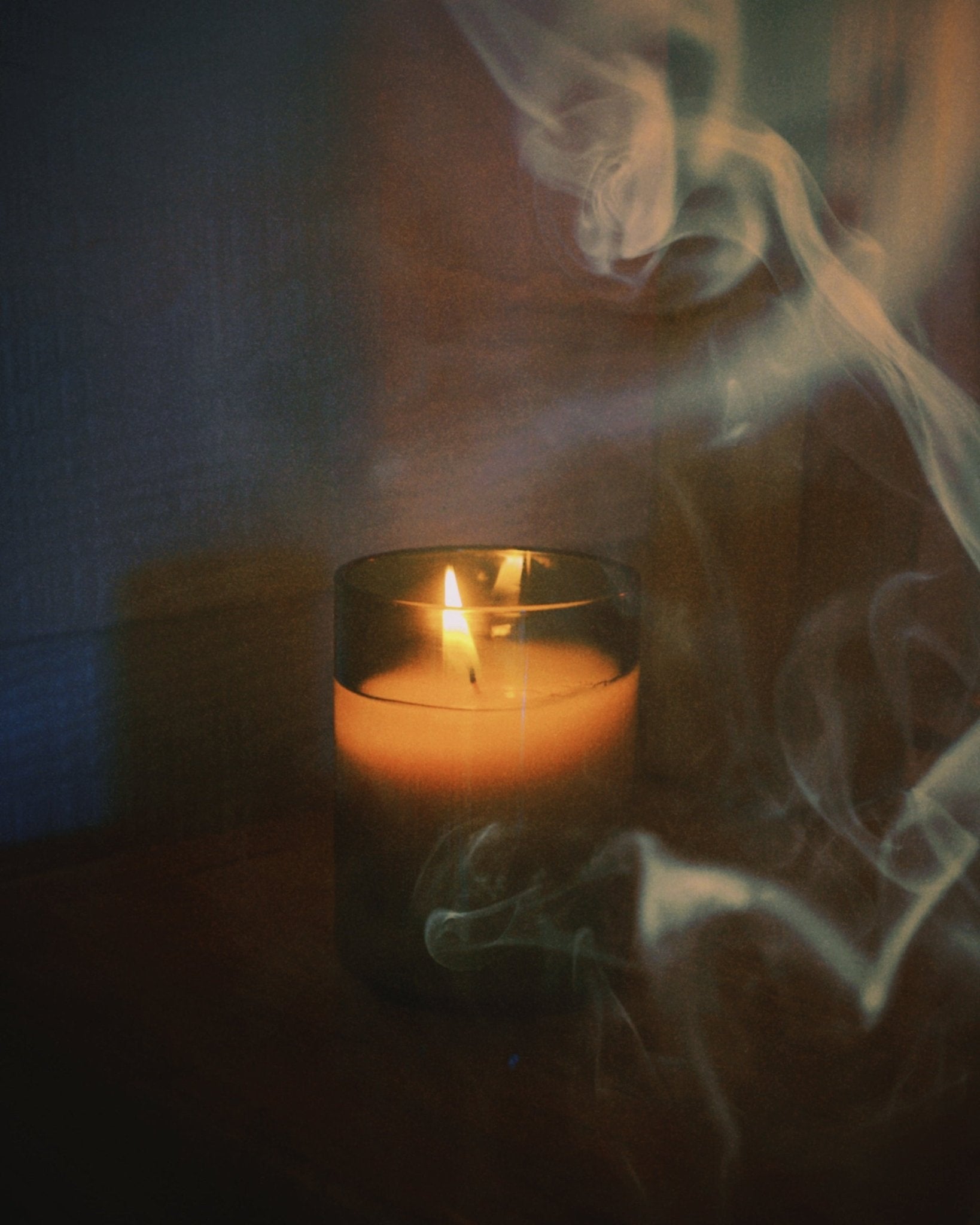 close up of burning light provisions woodsmoke candle with smoke in foreground and background