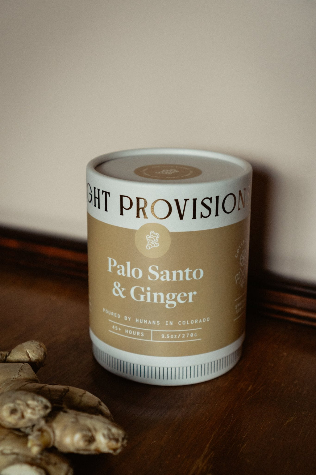 Palo Santo Ginger Candle in 9.5 oz ribbed glass tumbler with golden label styled with fresh ginger