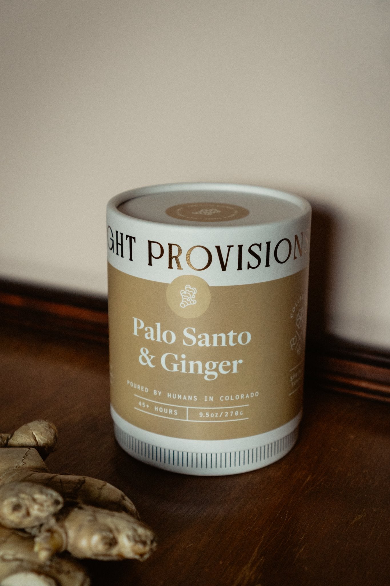 Palo Santo Ginger Candle in 9.5 oz ribbed glass tumbler with golden label styled with fresh ginger