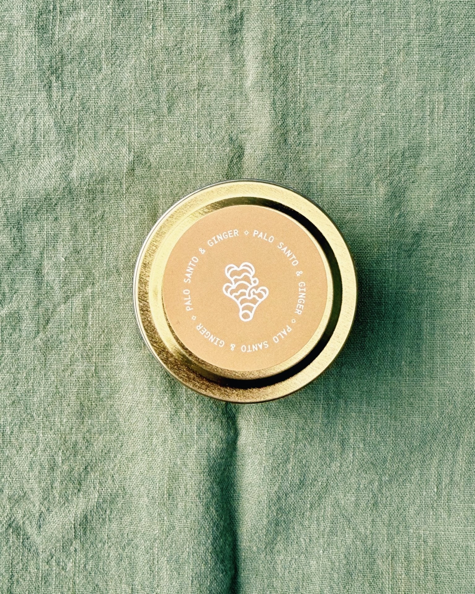 top down view of 2 oz tin palo santo ginger sample candle