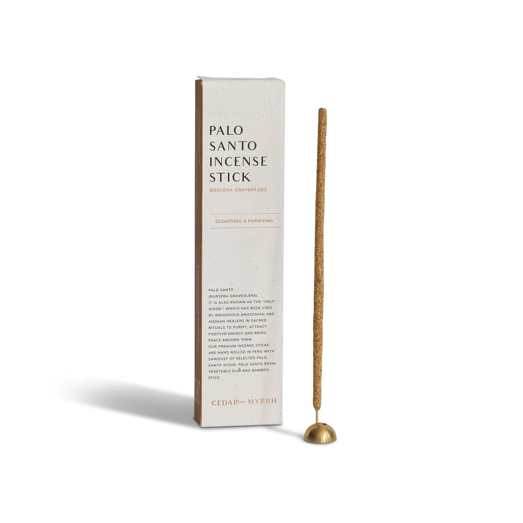 Palo Santo hand-rolled incense stick with brass holder, photographed beside the product box on a neutral background.