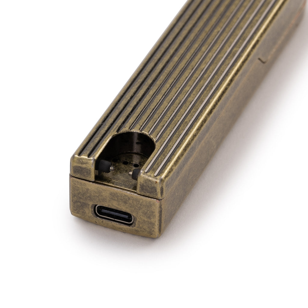 Close-up of the brass Pivot Arc Lighter showing USB-C charging port and ridged texture
