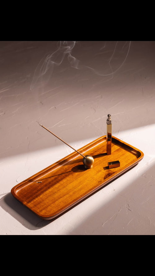 acacia wood tray containing burning incense, sphere holder, and queue stick lighter