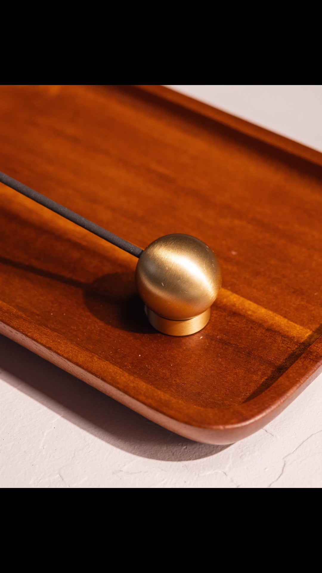 Stop motion video of sphere incense holder showing different angles for which to burn incense, on acacia wood tray