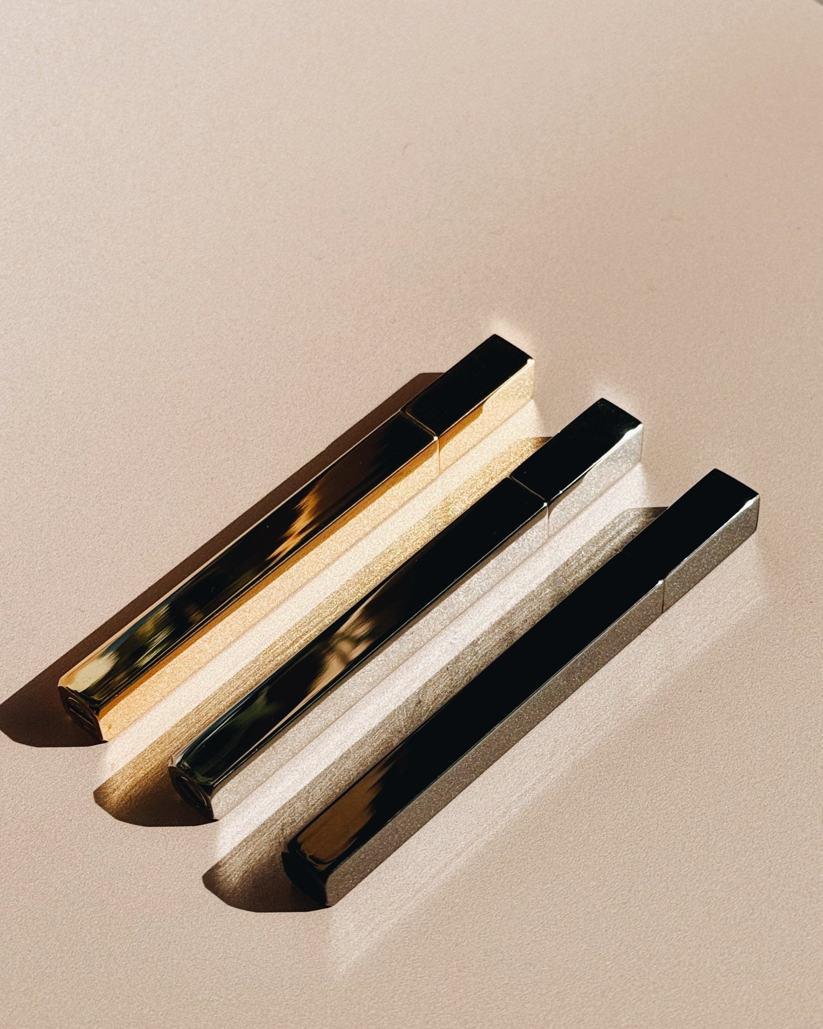 Three Queue Lighters by Tsubota Pearl in gold, silver, and gun metal