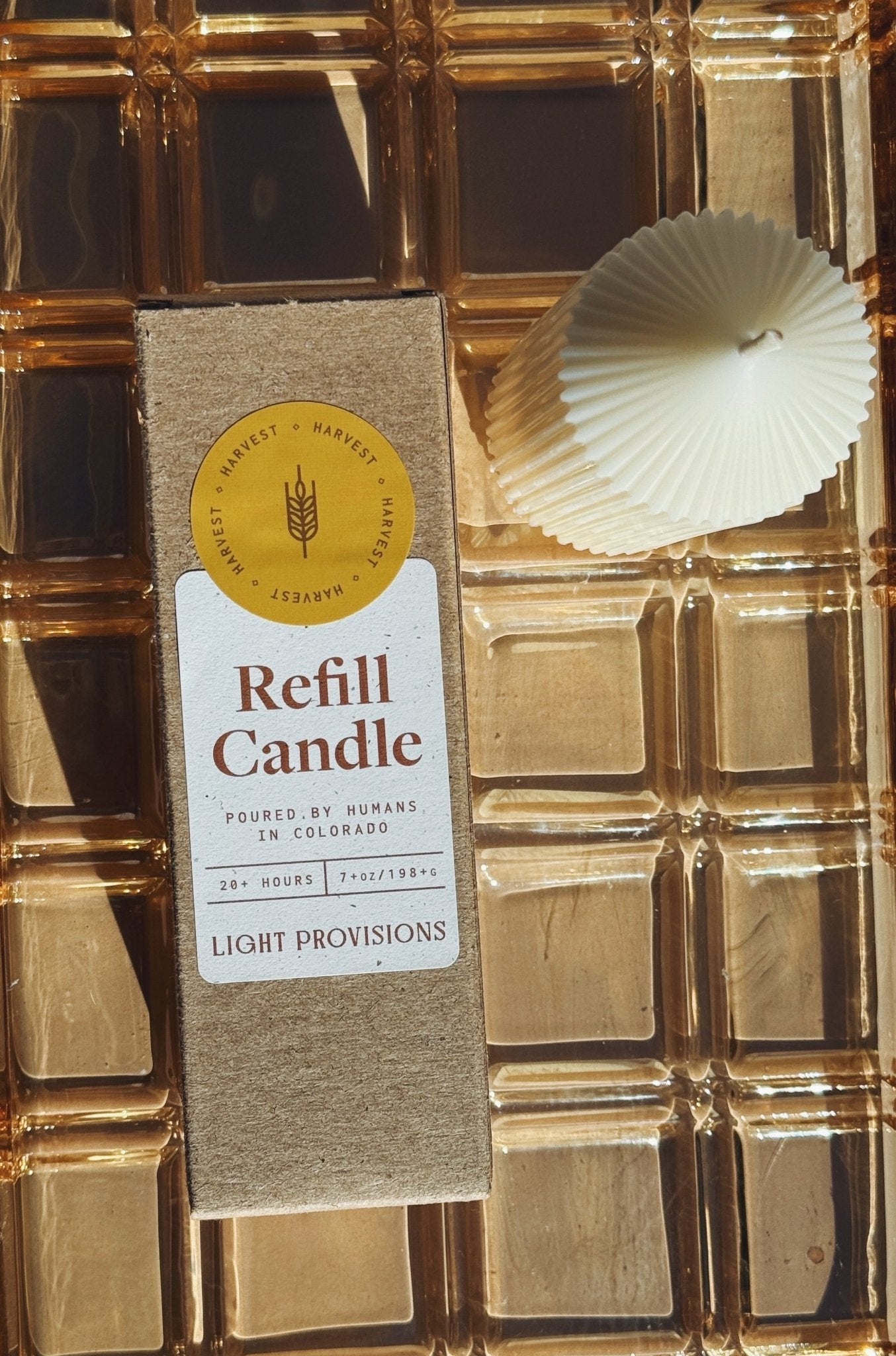 Harvest Refill candle with packaging on a gold textured background