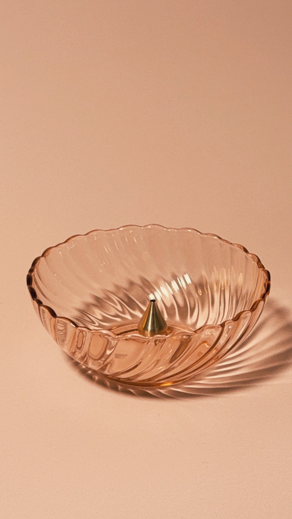 Vintage Rosaline Pink (Swirl Optic) by Cristal D’Arques–Durand with brass incense holder on beige background