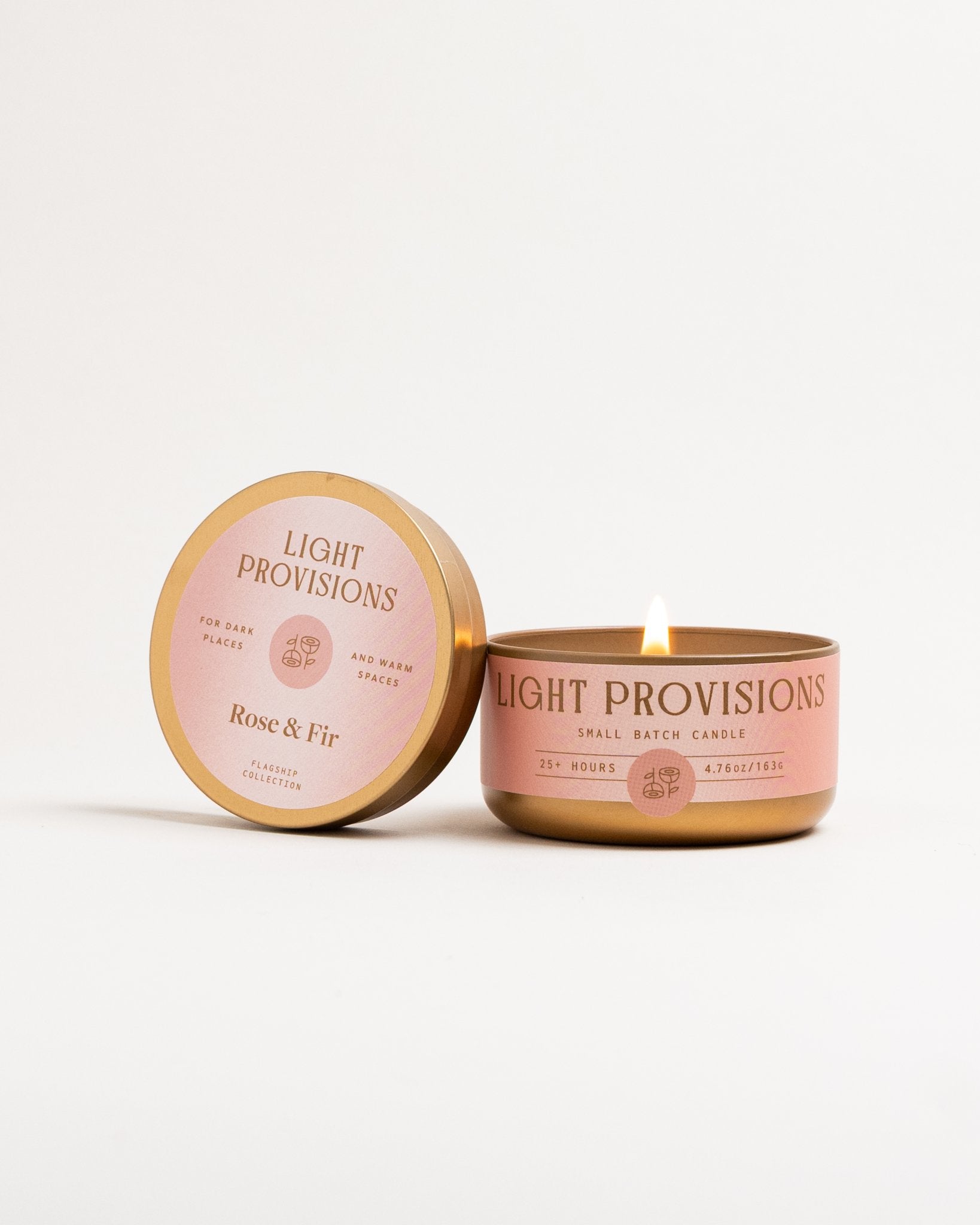 Rose & Fir candle tin with gold lid next to open candle on white background