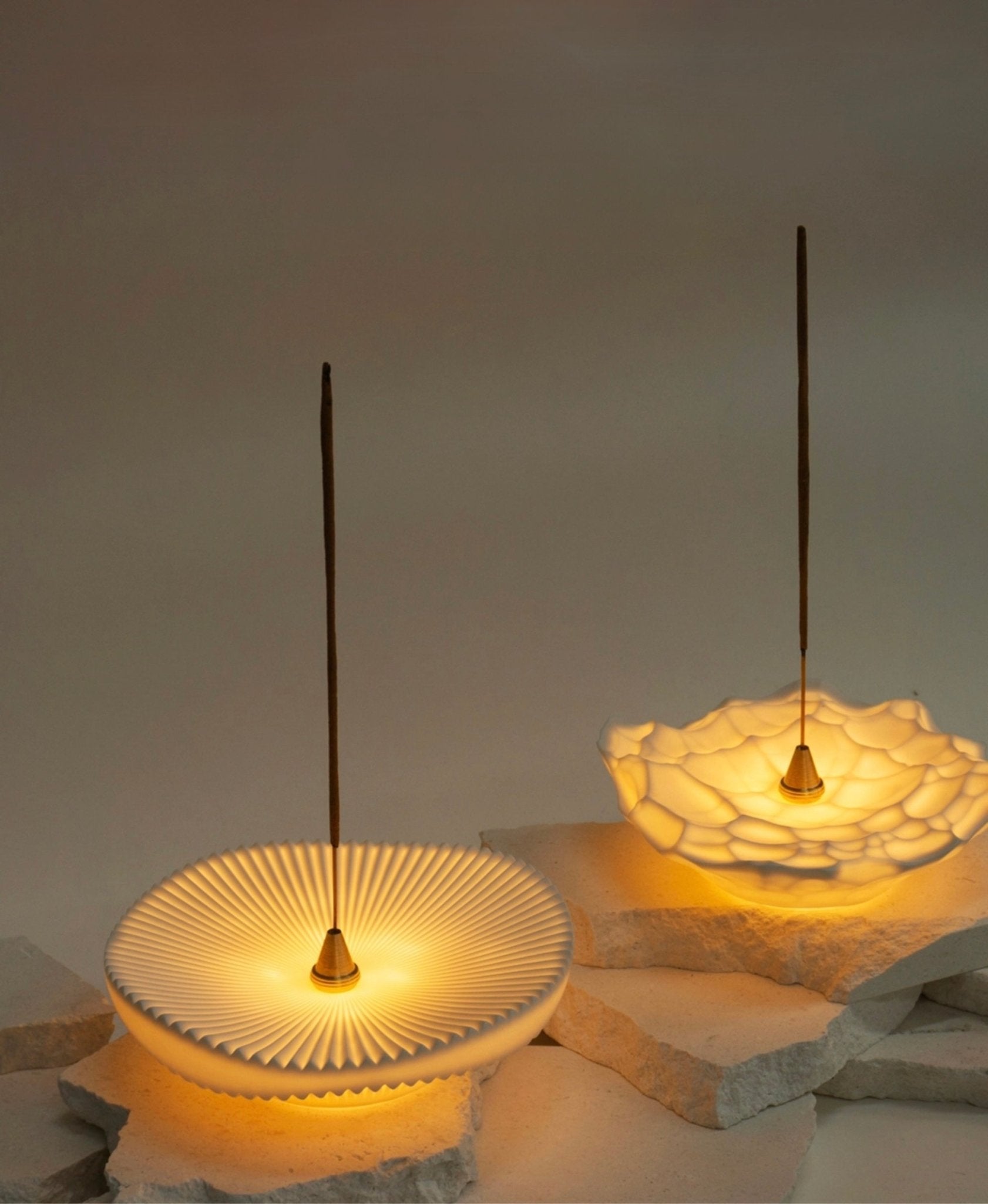 Softly glowing ceramic incense holders, in Gem and Vision designs, each with a lit LED light and incense stick